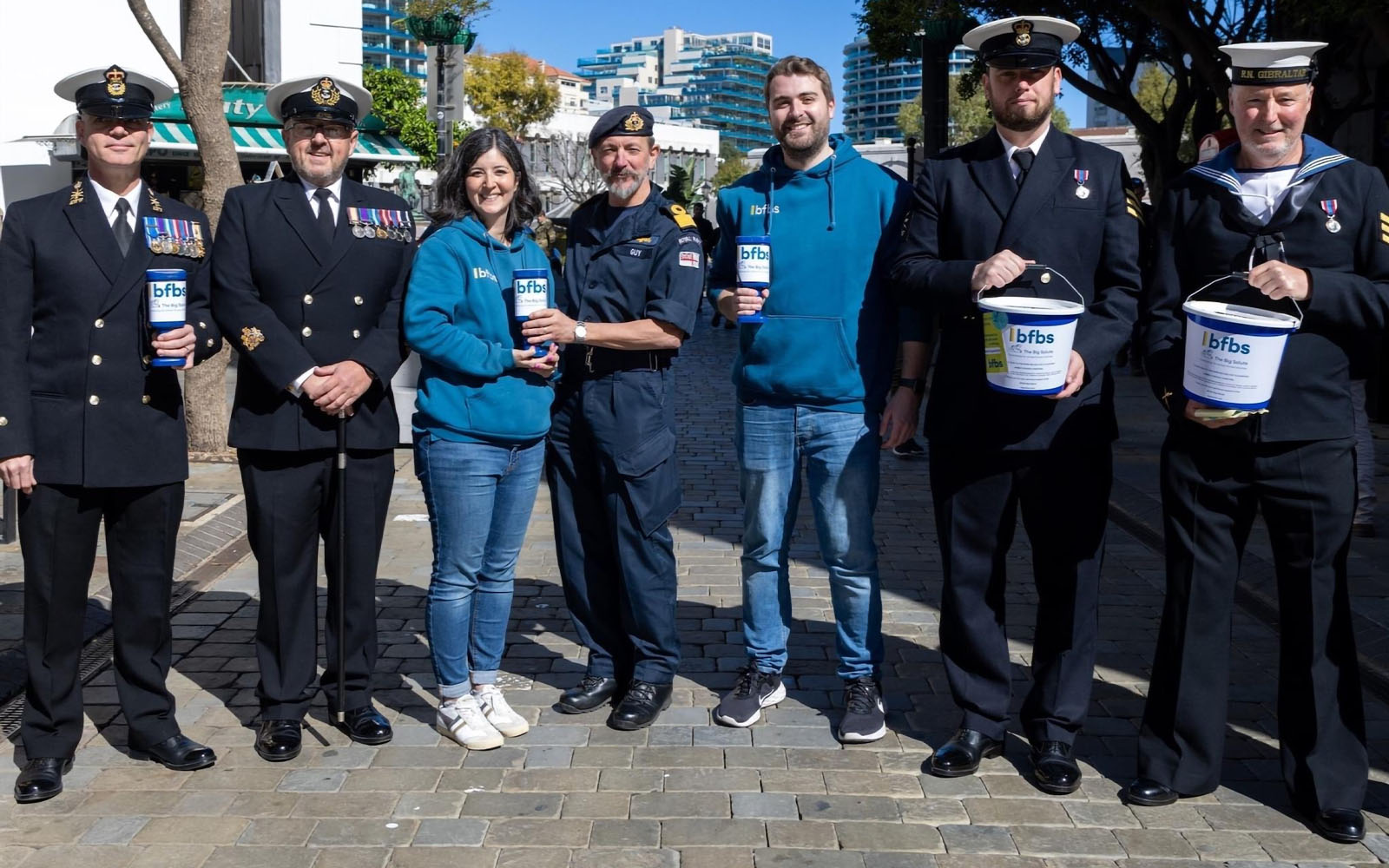 Team BFBS and armed forces volunteers on the streets of Gibraltar posing with BFBS Bug Salute collection buckets.