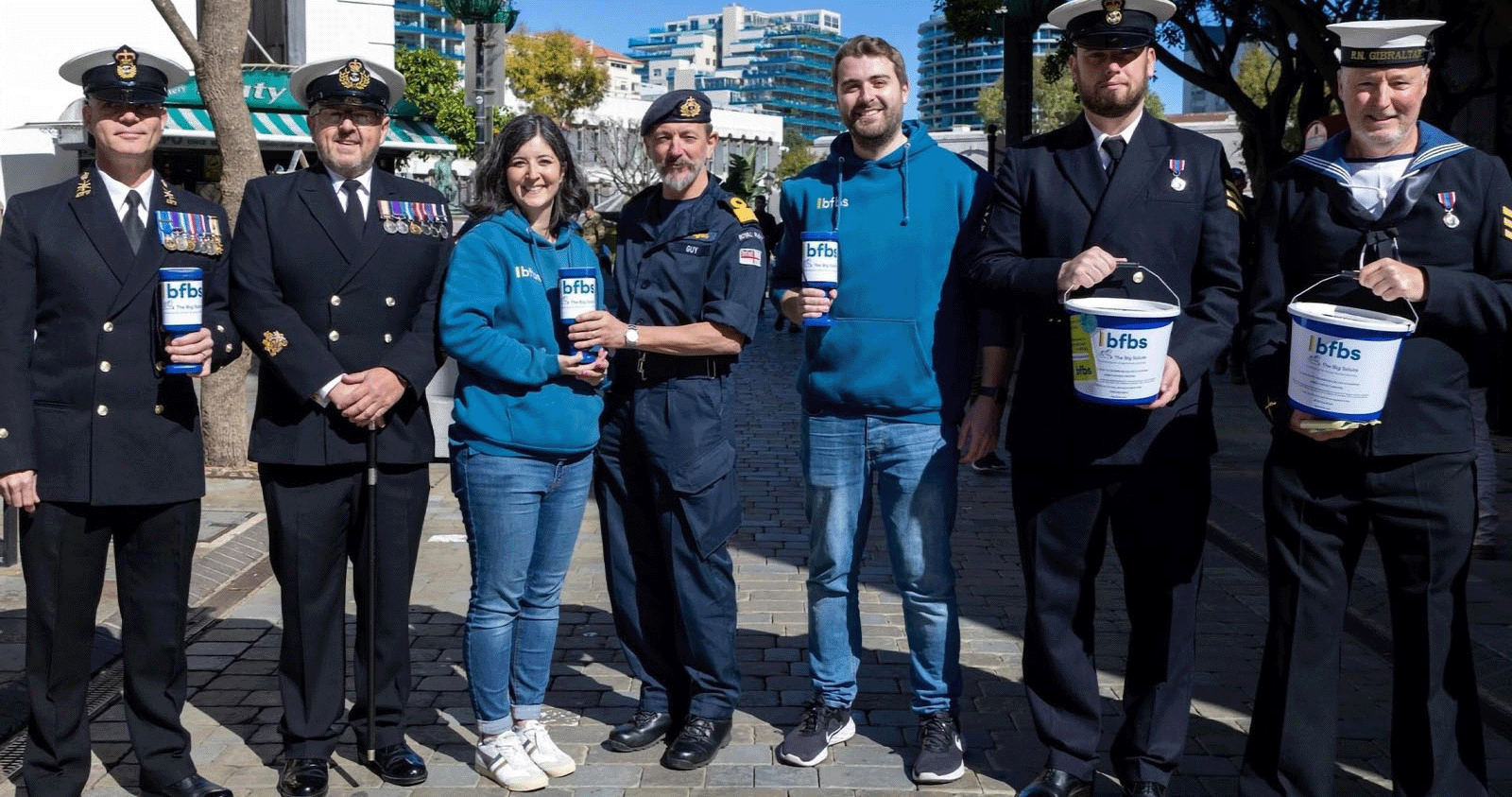 Team BFBS and armed forces volunteers on the streets of Gibraltar posing with BFBS Bug Salute collection buckets.