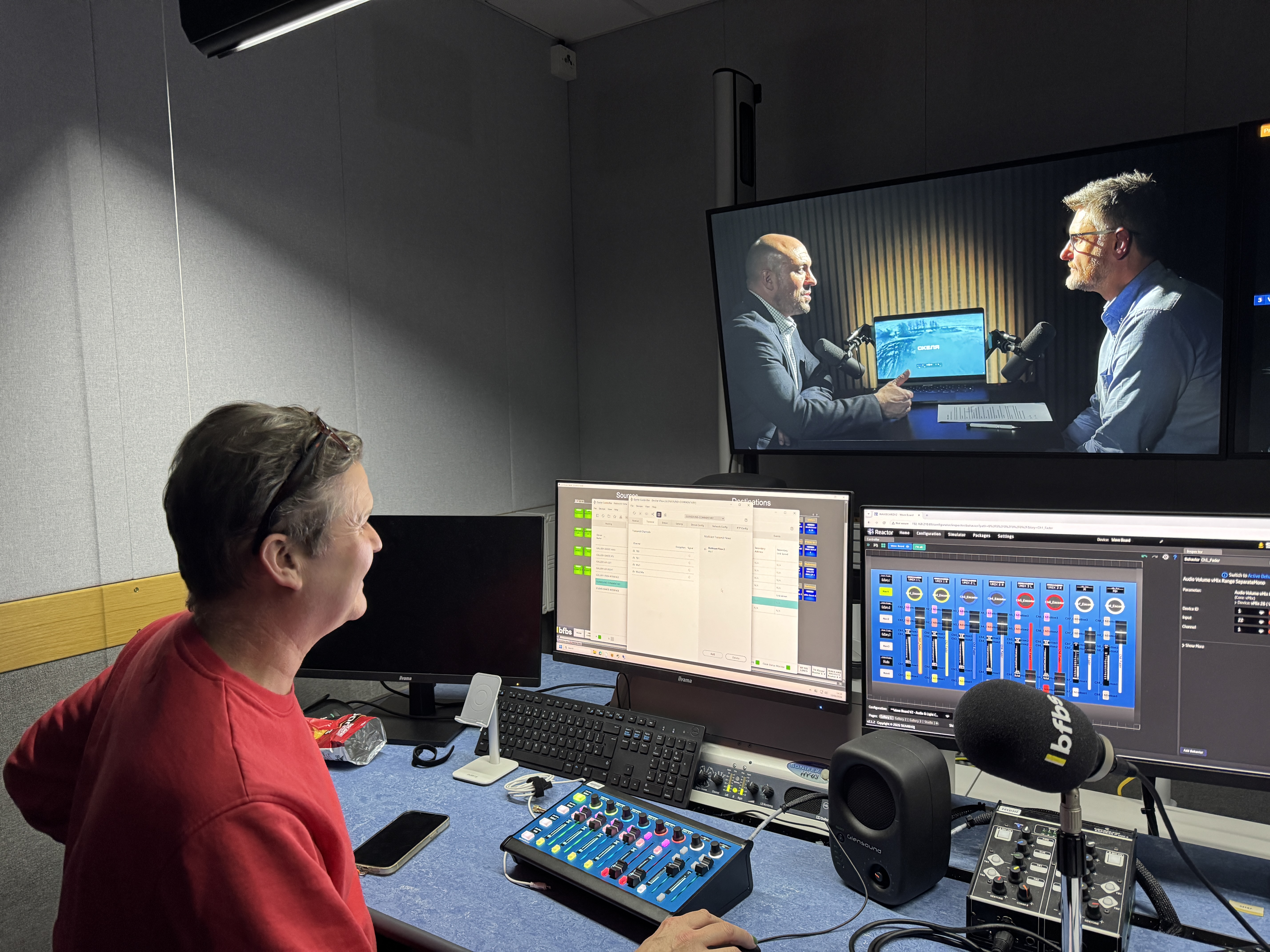 Video producer in front of video production screens