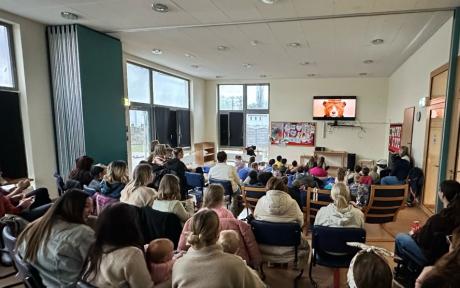 Room of people on chairs watching a film