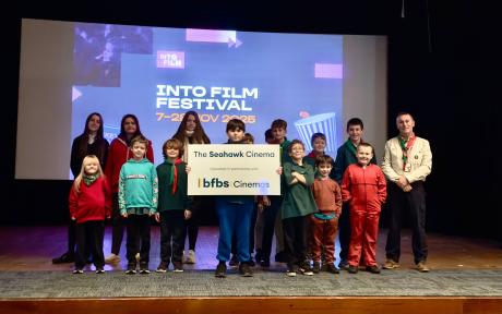Stage with young people holding a sign